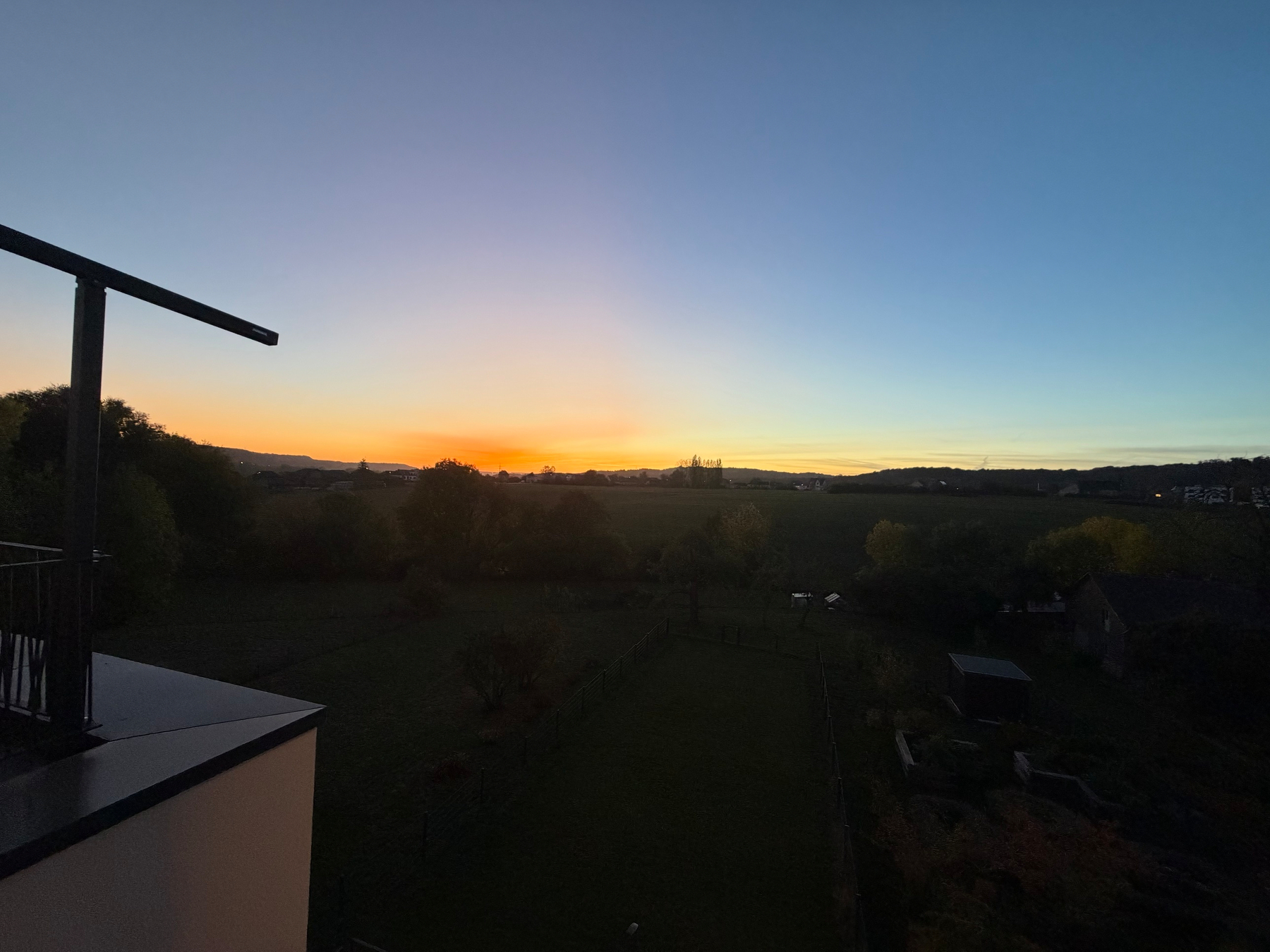 Oktober-Sonnenënnergank iwwer de Felder vun Hautcharage, vum Balkon aus